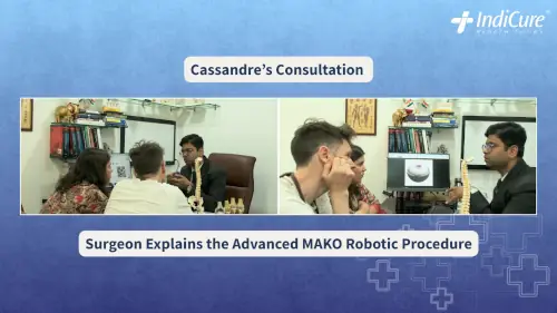 Cassandre and her partner consulting with an orthopedic surgeon in India, reviewing hip anatomy and advanced surgical planning technology (MAKO/3D model) on a computer screen.